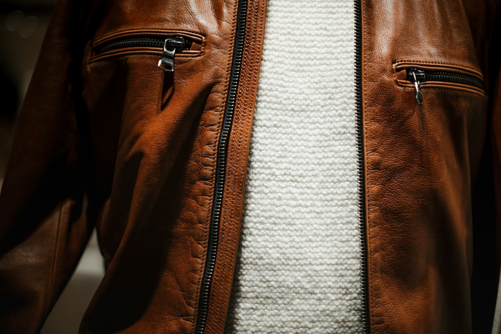 a close up of a person wearing a brown leather jacket